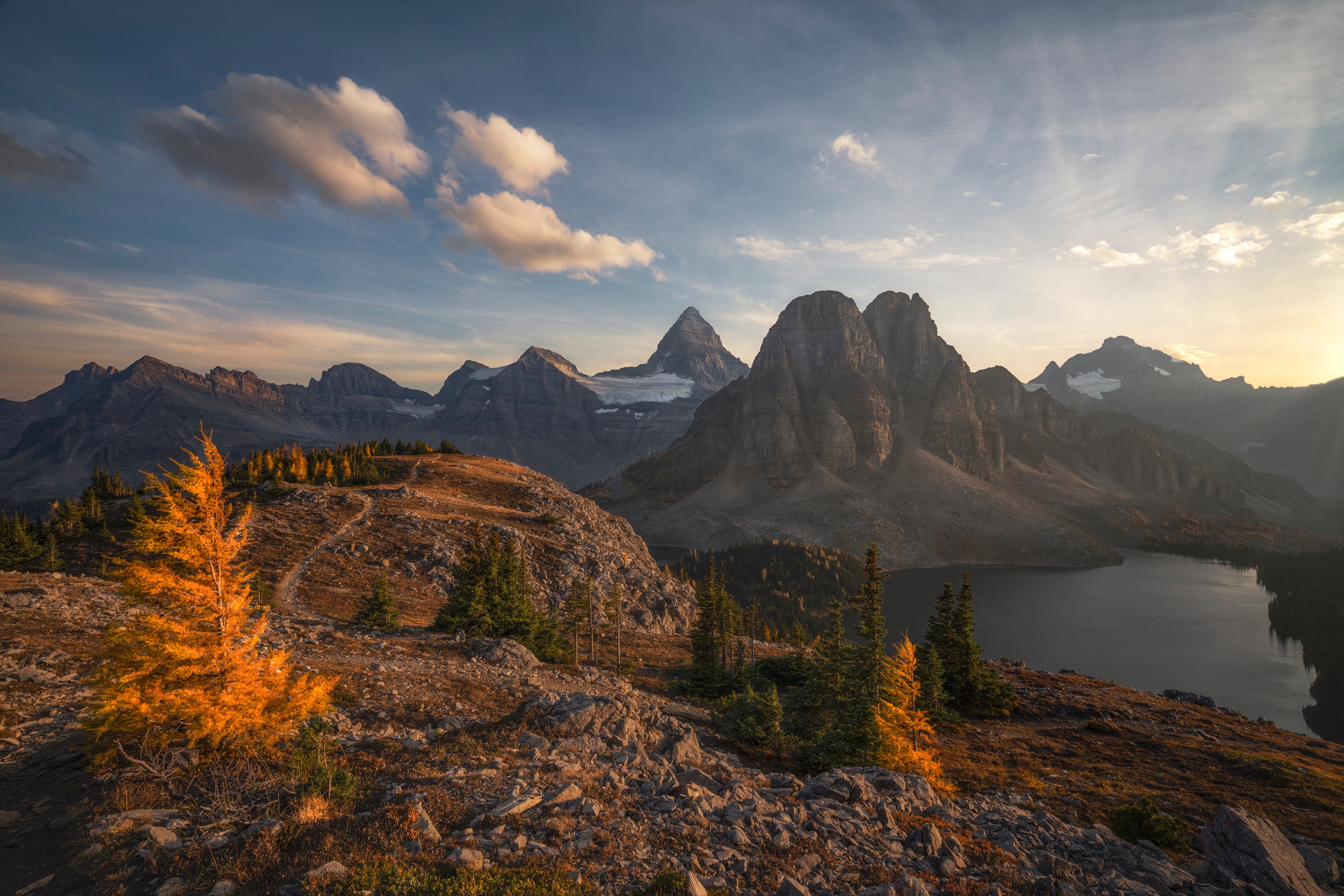 Mountain landscape with a lake and trees at sunset
