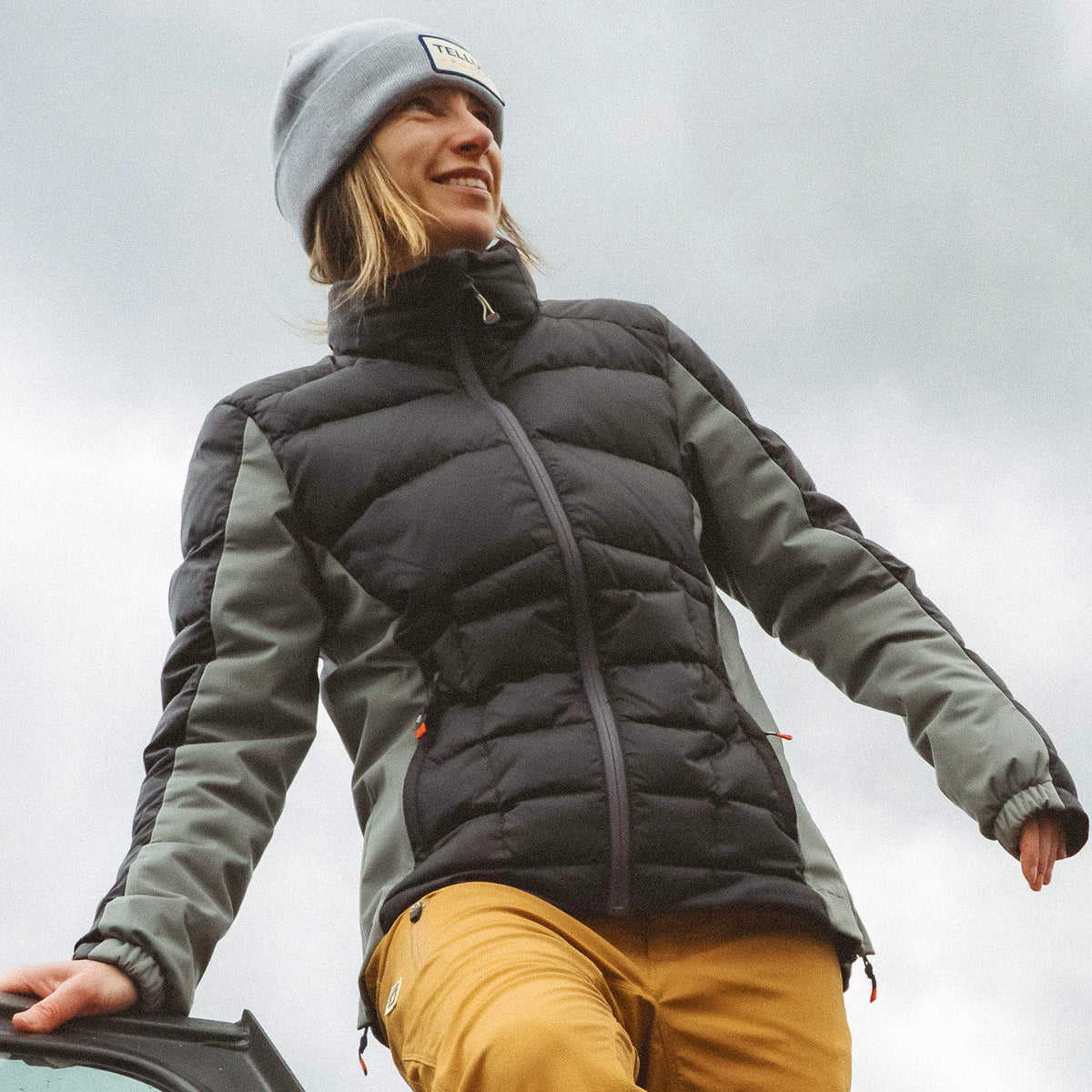 Woman wearing black Tellus Byers Peak Recycled Down Jacket and gray Tellus Beanie.